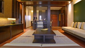 A modern kitchen with a central island, a dining area with a sofa, and a kitchen counter. - Emerald Palace Hotel (Naypyidaw)