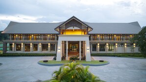 A large, modern building with a symmetrical facade, multiple balconies, and a central entrance with a covered walkway. - Emerald Palace Hotel (Naypyidaw)