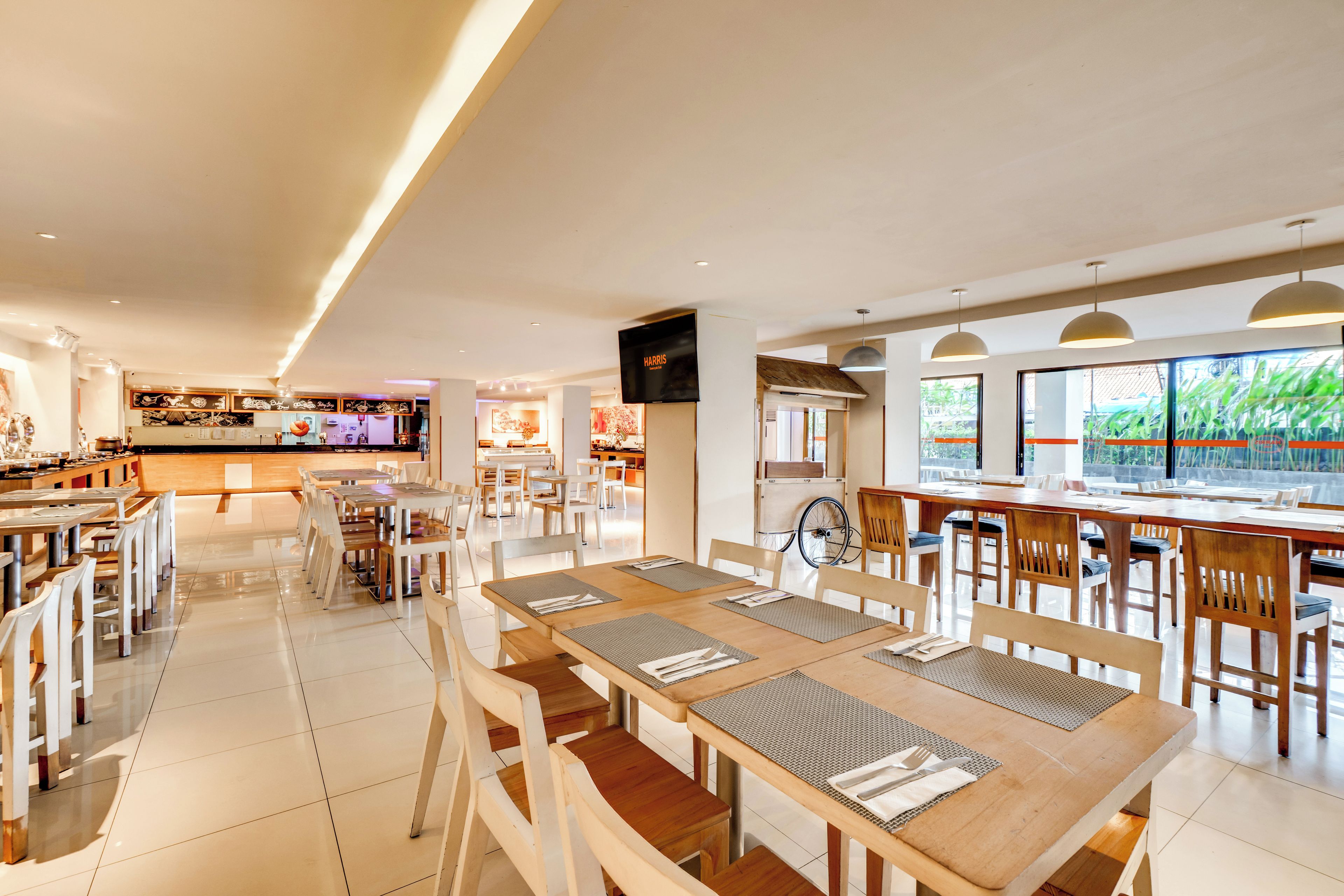 Un restaurante espacioso con varias áreas de comedor, un bar y una gran pantalla de televisión.
