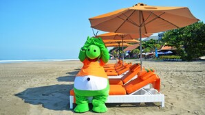 A beach with inflatable dinosaur chairs and umbrellas. - HARRIS Hotel Seminyak Bali (Seminyak)