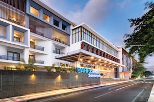 Hotel moderno com várias varandas, entrada imponente e placa indicando 'Harris Hotel Seminyak'.