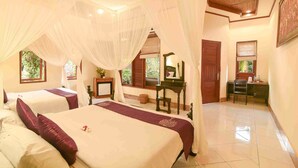 A hotel room with two beds, a desk, and a computer. - Nick's Pension (Ubud)