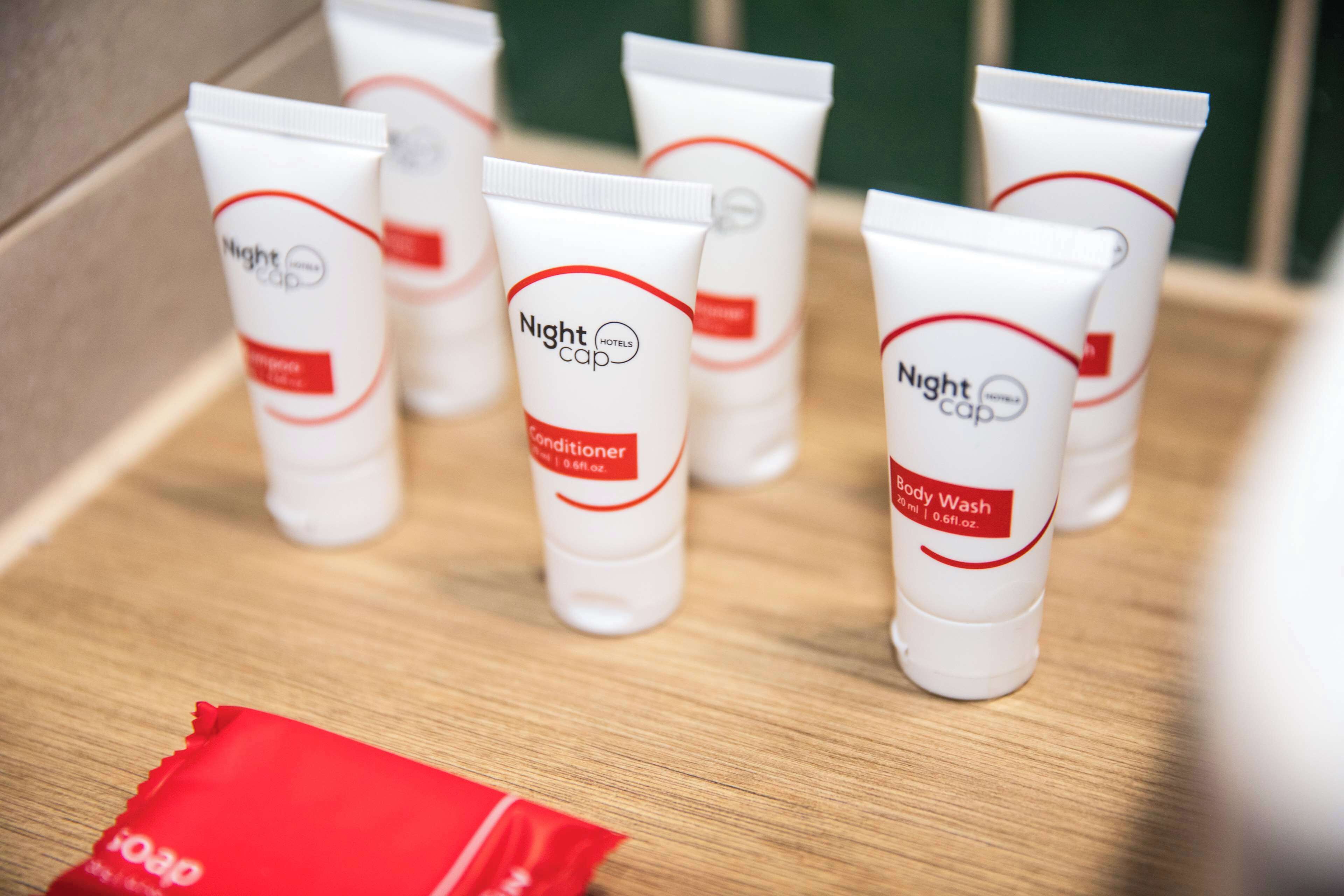 Several tubes of Nightcap body wash on a wooden surface.