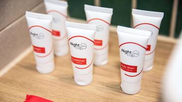 Several tubes of Nightcap body wash on a wooden surface.