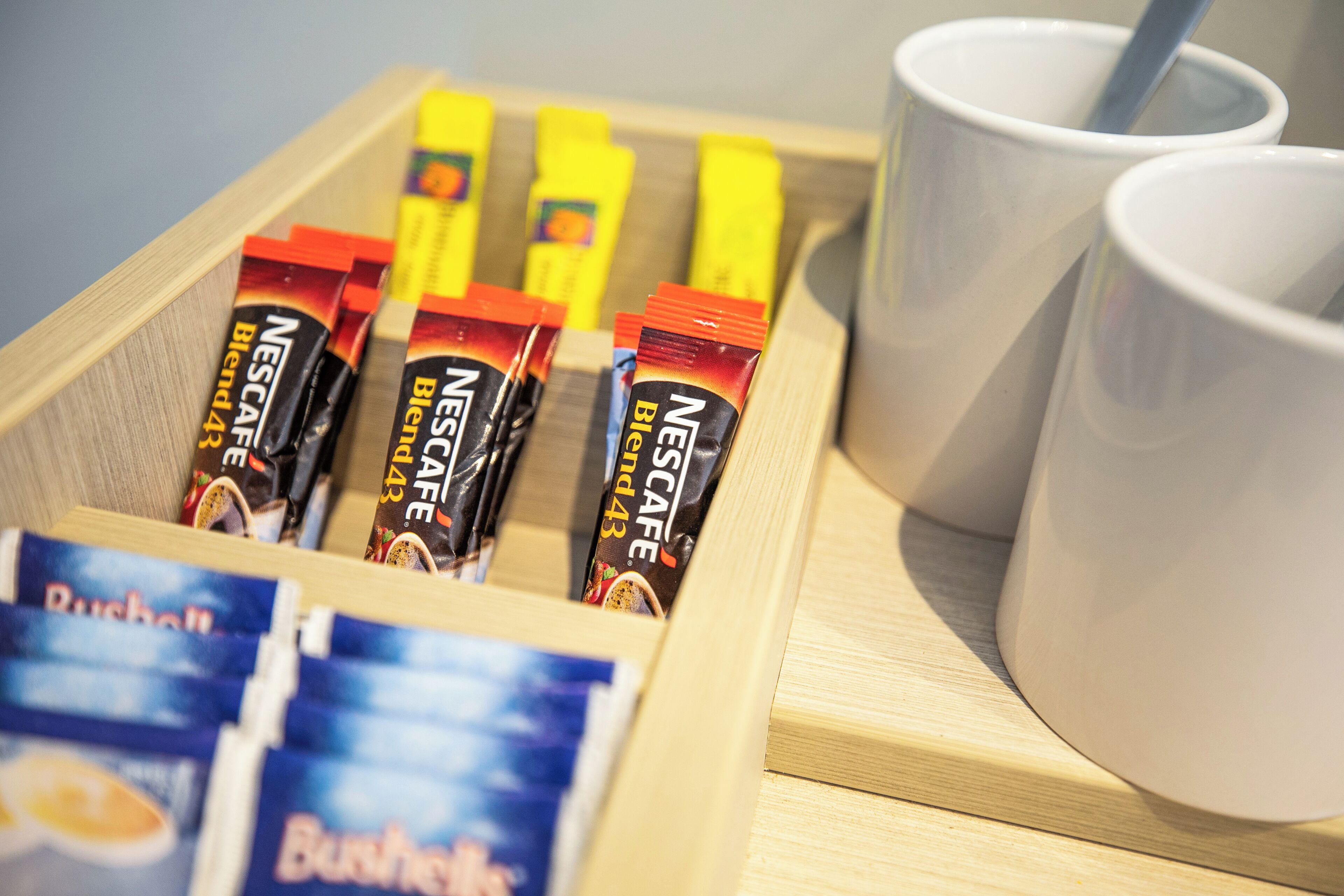 A tray with Nescafé Blend 43 coffee packets and a cup of coffee.