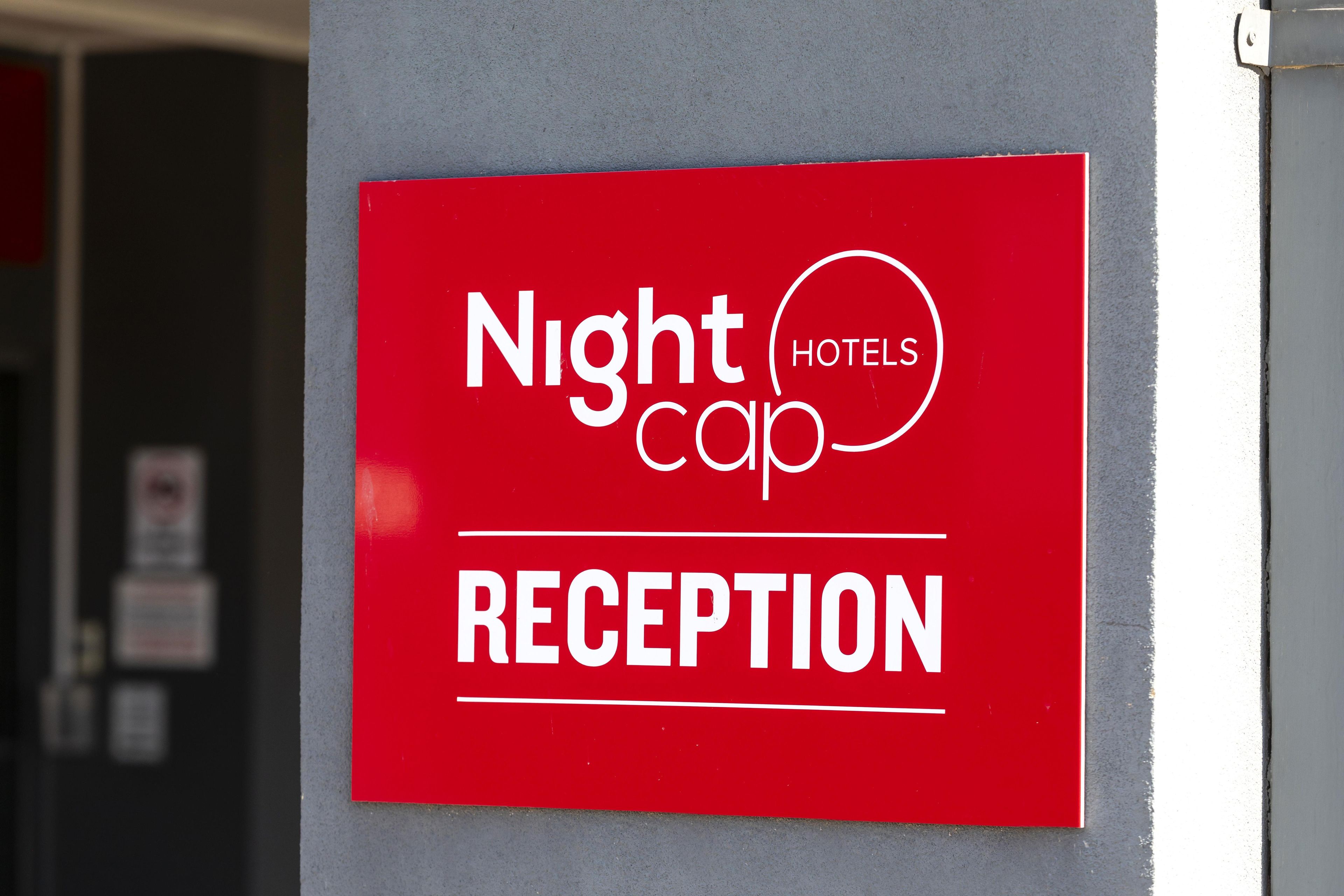 A red sign with white text indicating a 'Nightcap Hotels RECEPTION'.
