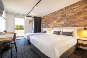 Una habitación de hotel moderna con una cama grande, un escritorio y una silla.