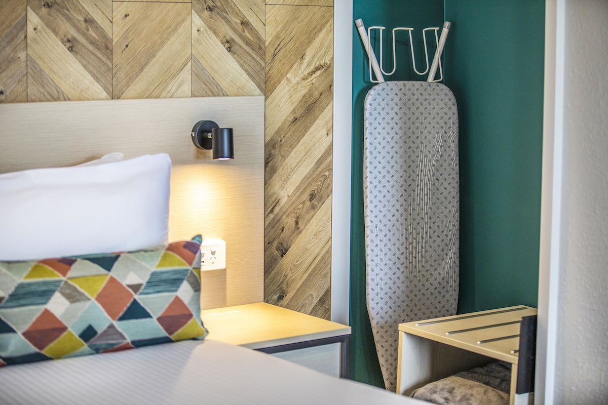 Tabla de planchar con plancha y ropa de cama