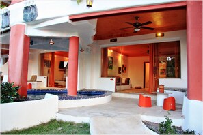 A hotel entrance with a pool, red pillars, and a ceiling fan. - Mirabel Resort & Mini Golf (Pattaya)