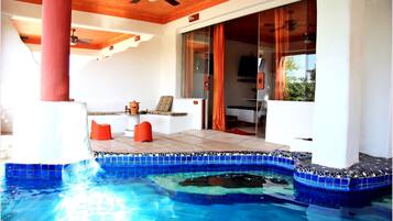 A pool area with a tiled edge, a table with chairs, and a sliding glass door leading to an interior space.