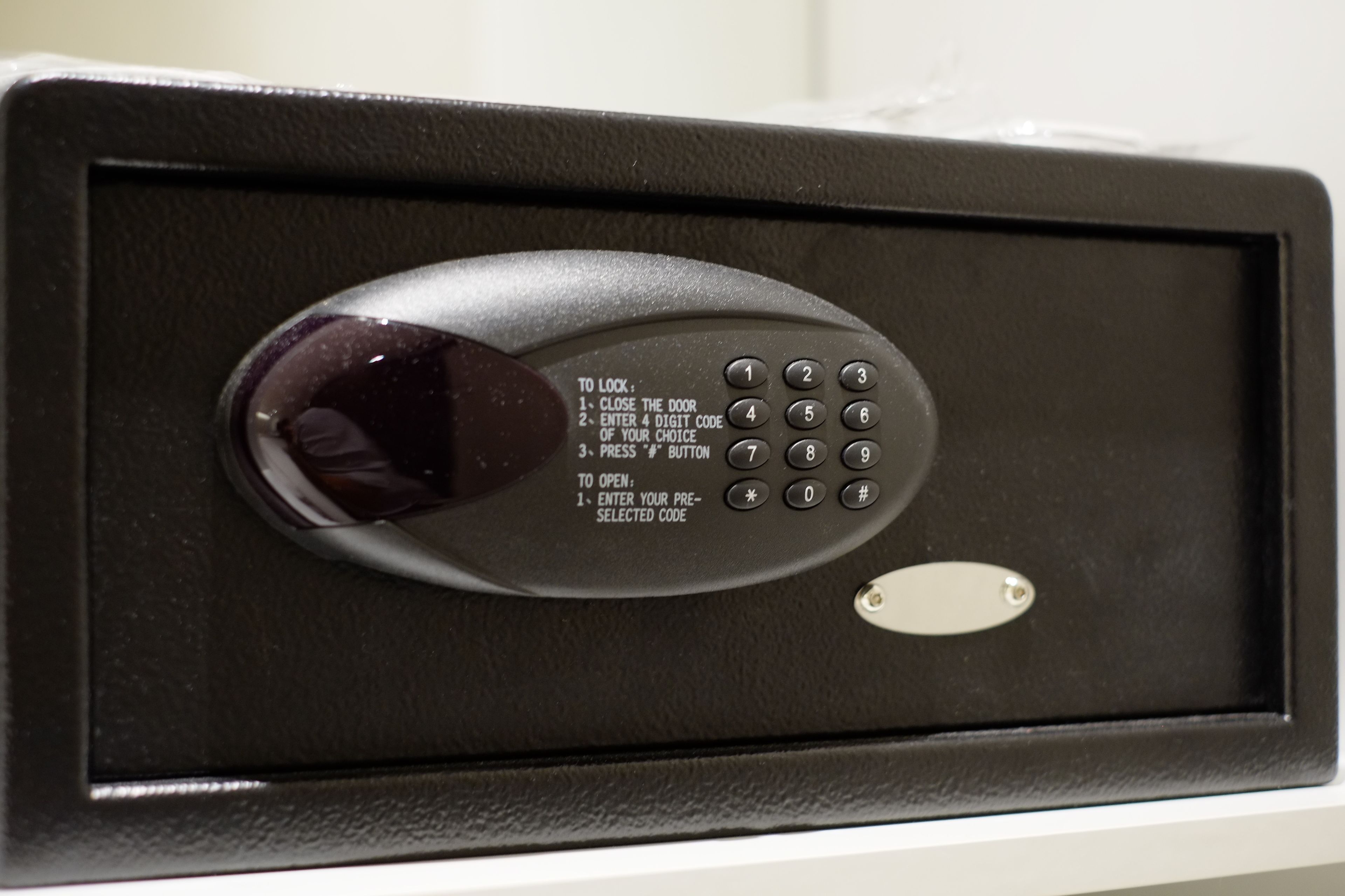 A black electronic keypad with instructions for locking and unlocking a door.