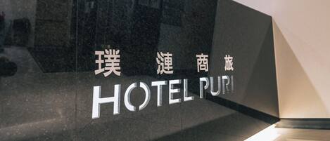Un letrero de hotel con el nombre 'HOTEL PURI' en inglés y caracteres chinos.
