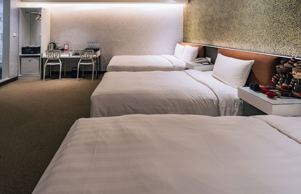 A hotel room with two beds, a desk with chairs, a minibar, and a decorative wall. - Hotel Puri Taipei Station Branch (Taipei)