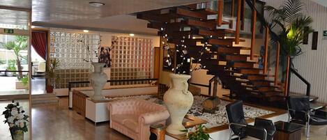 Un interior moderno con escalera, zona de estar y elementos decorativos.