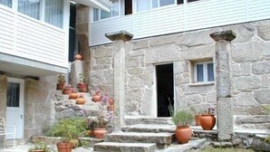 A stone staircase leading to a door, surrounded by potted plants. - Casa Rural O'Pozo (Cerdedo-Cotobade)