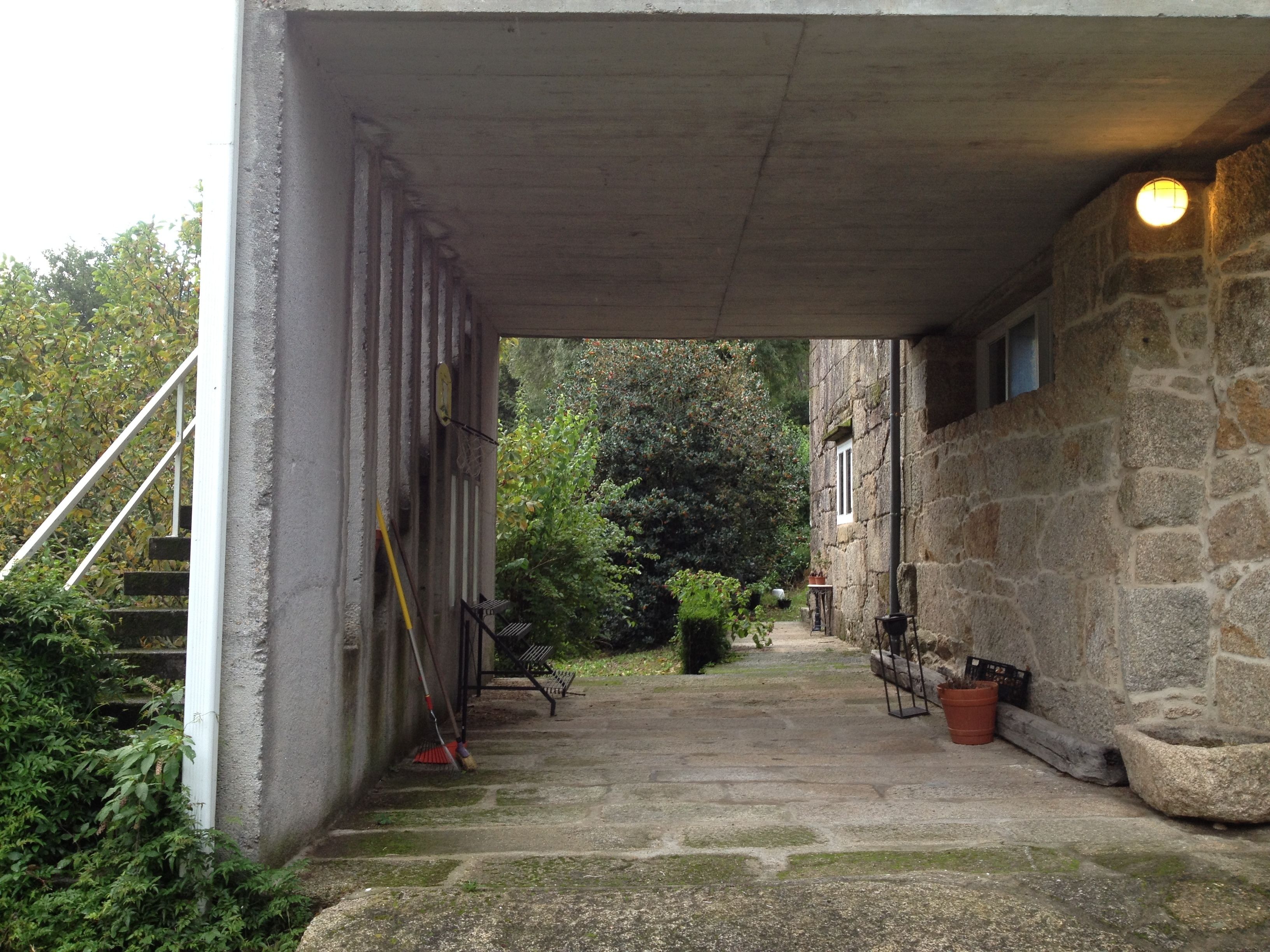 Un edificio de piedra con un porche cubierto, una escalera y un sendero que lleva a una puerta.