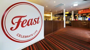 A hotel lobby with a prominent 'Feast' sign, a patterned carpet, and a reception desk. - Nightcap at Gateway Hotel (Corio)
