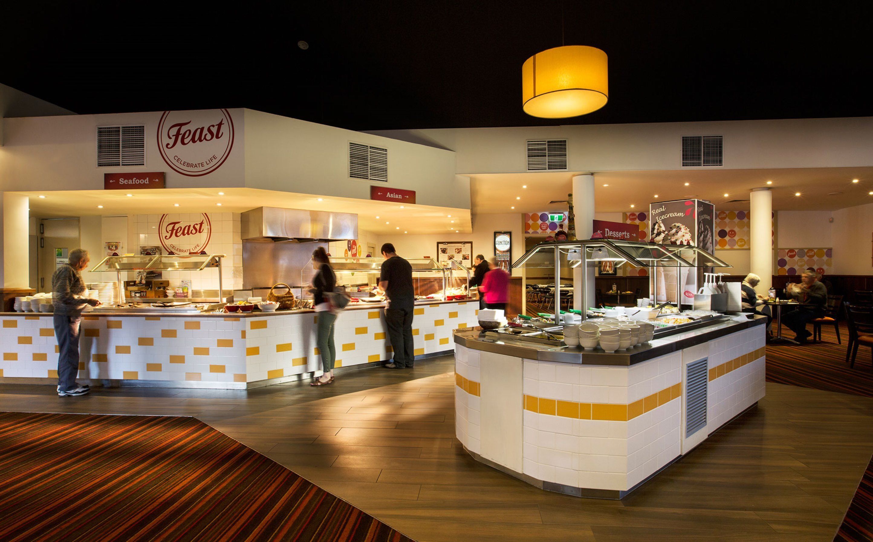 A buffet area with multiple food stations, including seafood and Asian cuisine, and a dessert section.