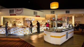 A buffet area with multiple food stations, including seafood and Asian cuisine, and a dessert section.