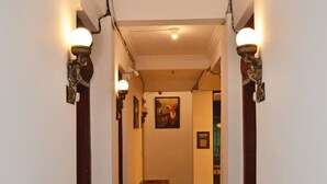 Un pasillo con un banco, luces empotradas en la pared y un cuadro colgado.