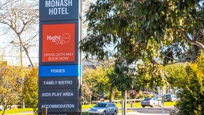 A sign for Monash Hotel with amenities listed including a family bistro, kids play area, and accommodation.