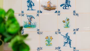 A tiled wall with various blue and white patterns, including figures and flowers.
