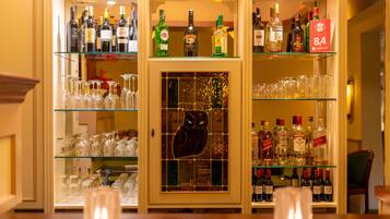 Zona de bar con estanterías llenas de botellas de licor y vasos.