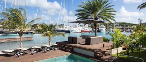 Una piscina al aire libre, sillones reclinables de piscina