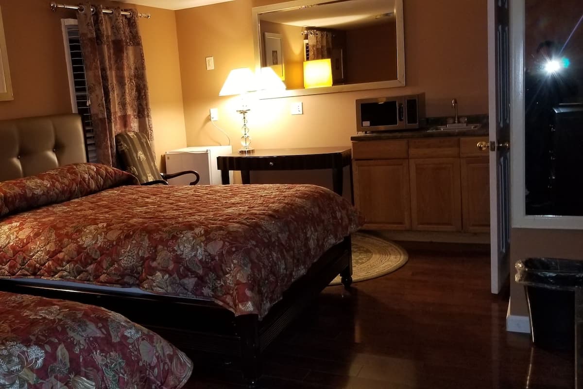 Een hotelkamer met een groot bed, een bureau, een stoel, een televisie en een badkamer.