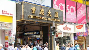 A busy street with a prominent sign for 'CHUNGKING MANSIONS'. - New Tokyo Hostel (Kowloon)