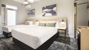 A hotel room with two beds, a large abstract painting, a wooden headboard, a nightstand, and a mirror. - Nightcap at Rex Hotel (Marleston)