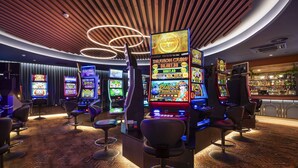 A casino with multiple slot machines, bar area, and bar stools. - Nightcap at Rex Hotel (Marleston)