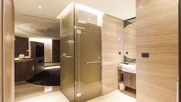 A modern bathroom with a glass shower enclosure, a vanity with a sink, and a mirror.