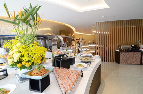 A buffet with various dishes and a large floral centerpiece.
