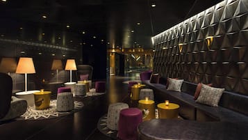 A modern lounge area with seating arrangements, tables, and ambient lighting.