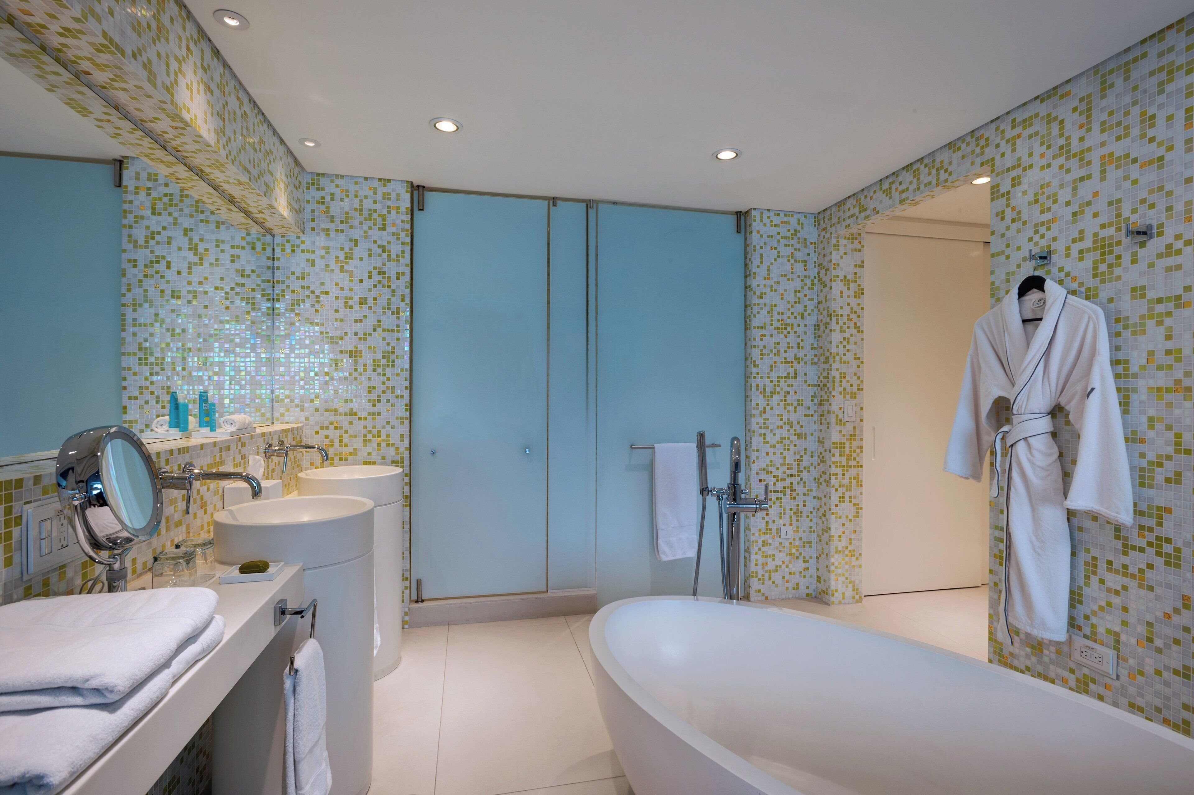 Une salle de bain moderne avec une grande baignoire, un meuble-lavabo avec un miroir et un espace douche.