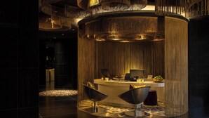 A reception area with a circular desk, two modern chairs, and a patterned floor. - W Bogota (Bogotá)