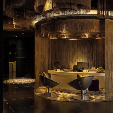 A reception area with a circular desk, two modern chairs, and a patterned floor.