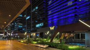 A modern hotel with a prominent 'W' logo, outdoor seating, and a well-lit atrium. - W Bogota (Bogotá)