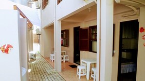 A corridor with tiled flooring, white furniture, and a refrigerator. - Ingleses Residence (Florianópolis)