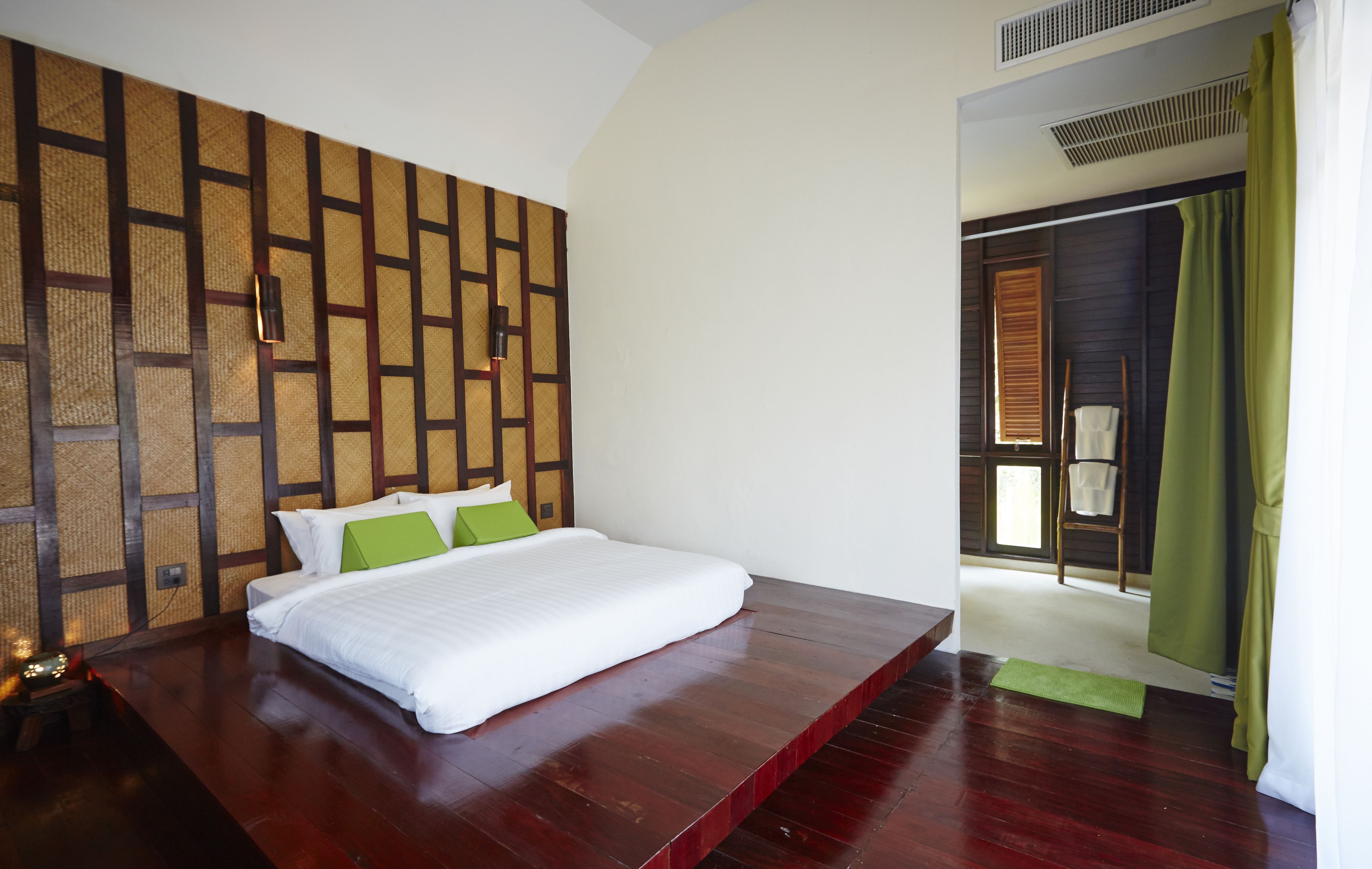Un dormitorio con una cama grande, un cabecero de madera y vistas a una puerta de madera.