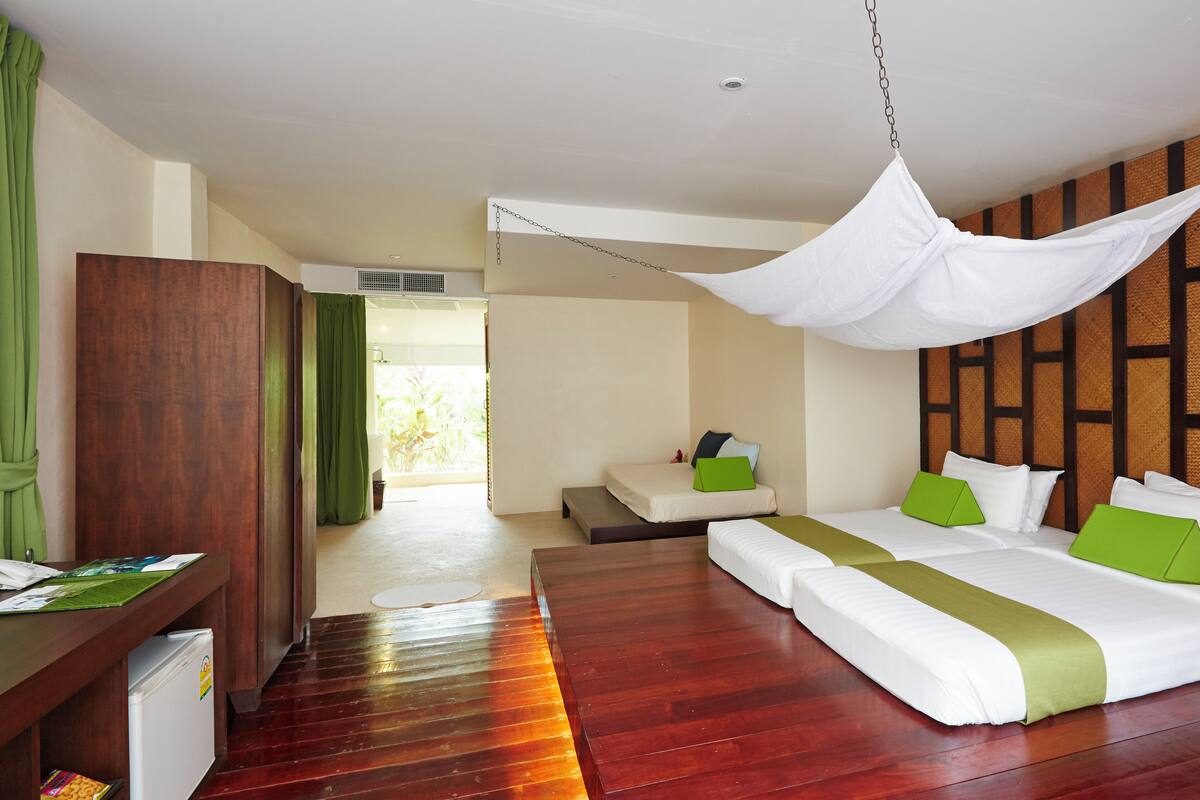 A hotel room with a bed, bedside tables, a desk, and a wardrobe.