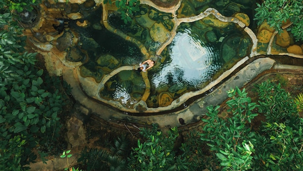 An aerial view of a natural water feature surrounded by dense greenery. - Wareerak Hot Spring & Wellness (Khlong Thom)