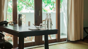 Une table en bois avec un téléphone, une bouteille en verre et un bocal en verre.