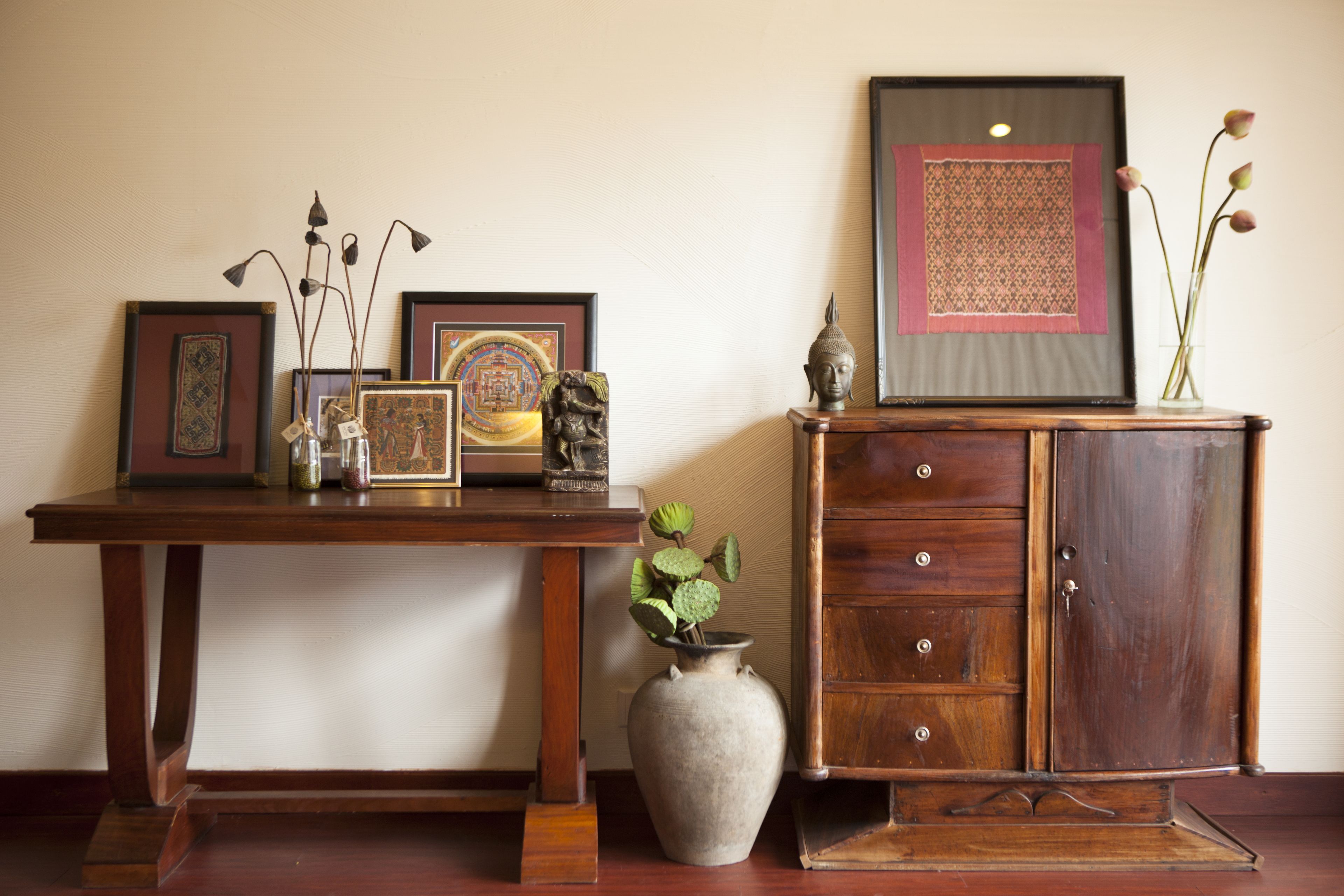 A wooden cabinet with drawers and a vase with flowers on top.
