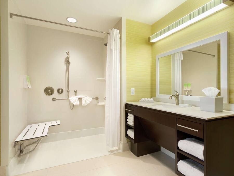 Un bagno moderno con doccia, uno specchio grande e un mobile lavabo.