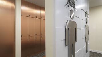 A hallway with lockers, a bench, and a wall-mounted shower system.