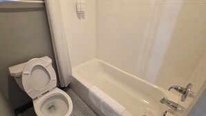 Un baño con inodoro, bañera y ducha.