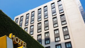 A hotel building with a modern design, featuring a prominent 'HOTEL' sign in the foreground and a 'WO' logo on the building. - Wo (Kaohsiung)