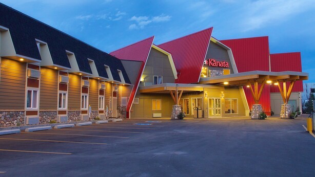 Un hotel con un diseño arquitectónico moderno, que destaca por su techo rojo y una entrada bien iluminada.